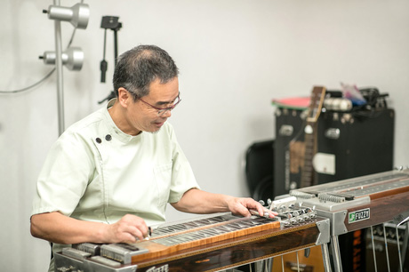 ペダルステイ―ルギターを演奏する院長